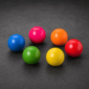 Lot de 6 cochonnets de pétanque fluo bleu, rose, orange, rouge, vert et jaune sur fond anthracite.